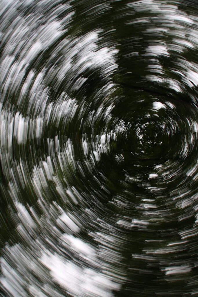 Captivating spiral motion blur of leaves creating an abstract, surreal effect.